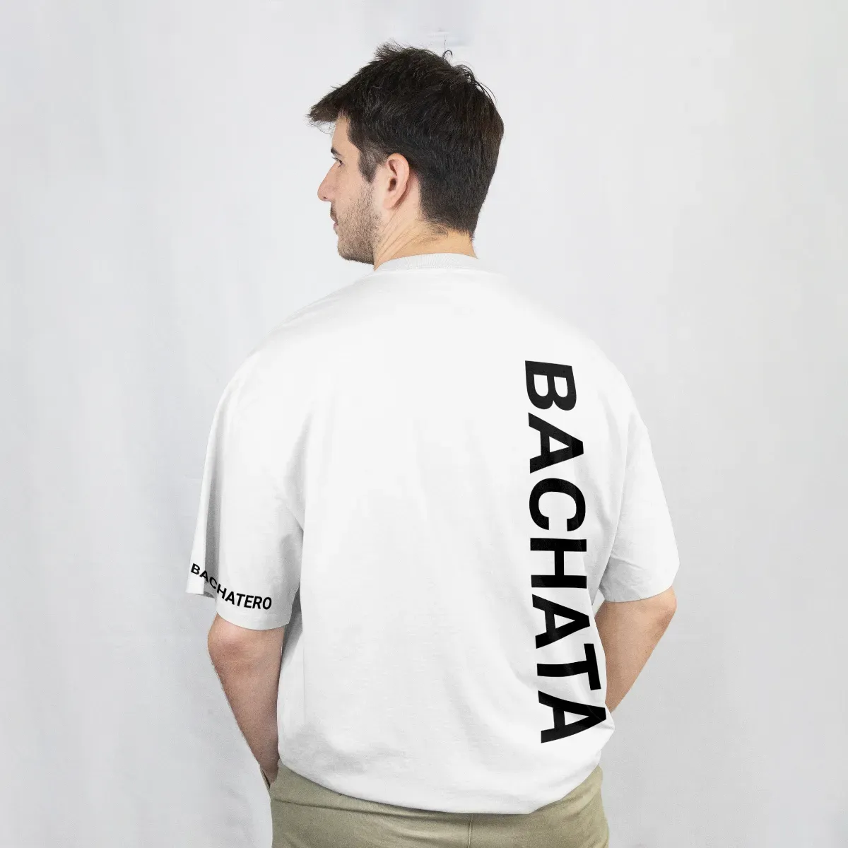 Playera blanca de espalda con la palabra Bachata en vertical, en negro, sobre el hombro y la manga
